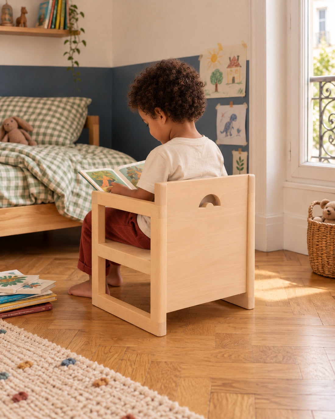 Un enfant s’installe sur sa chaise avec un album.