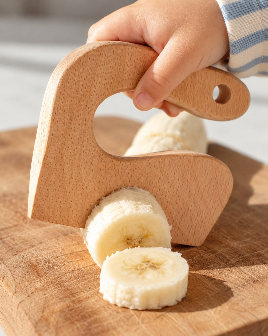 Le couteau en bois en action sur une banane.