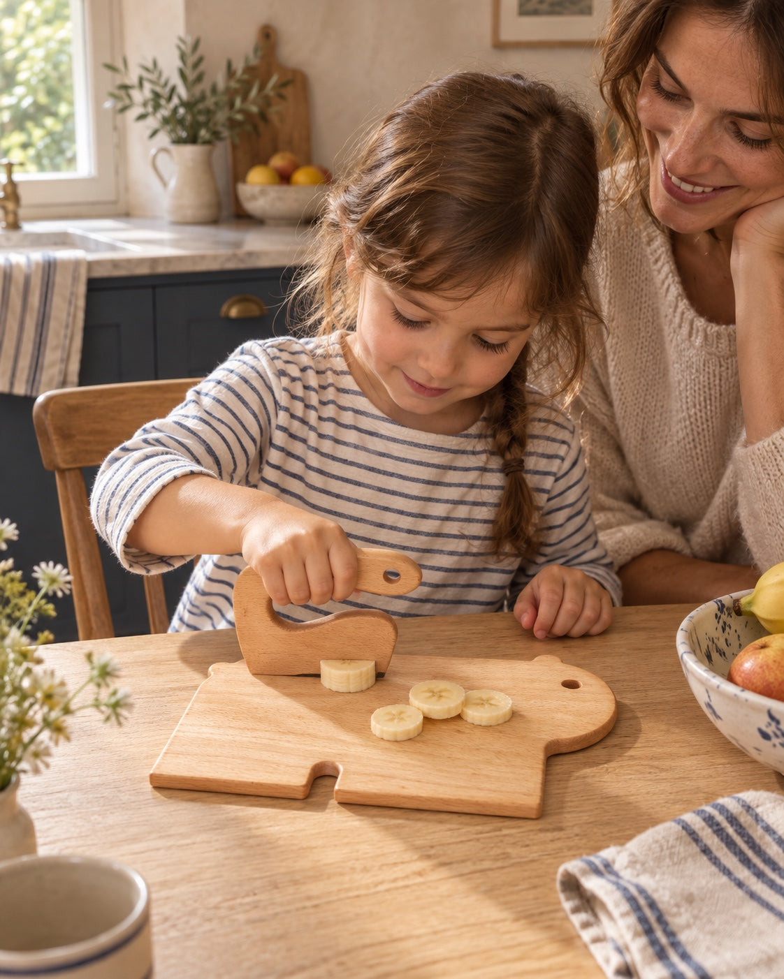 Une enfant prépare des fruits sur la planche ours.