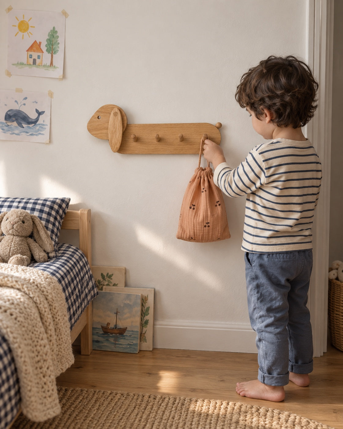 Une place pour ses petites affaires. Dans sa chambre, un enfant accroche son petit sac au porte-manteaux lapin en chêne naturel.