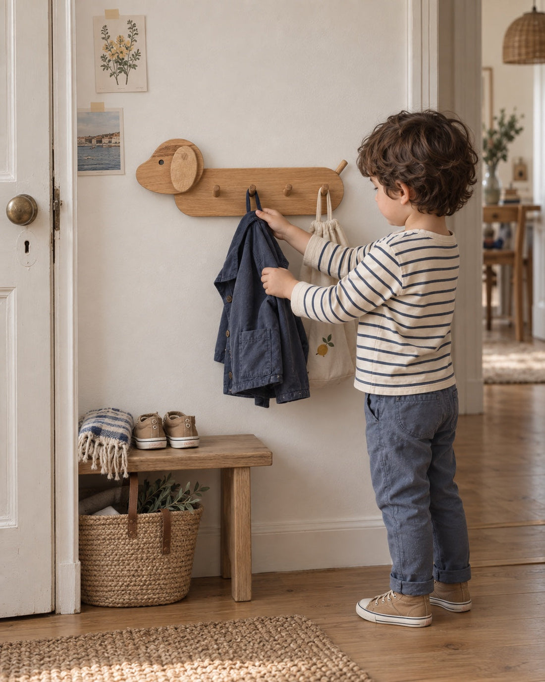 Prêt pour la journée. Dans l’entrée, un enfant prend sa veste sur le porte-manteaux chien en chêne naturel.