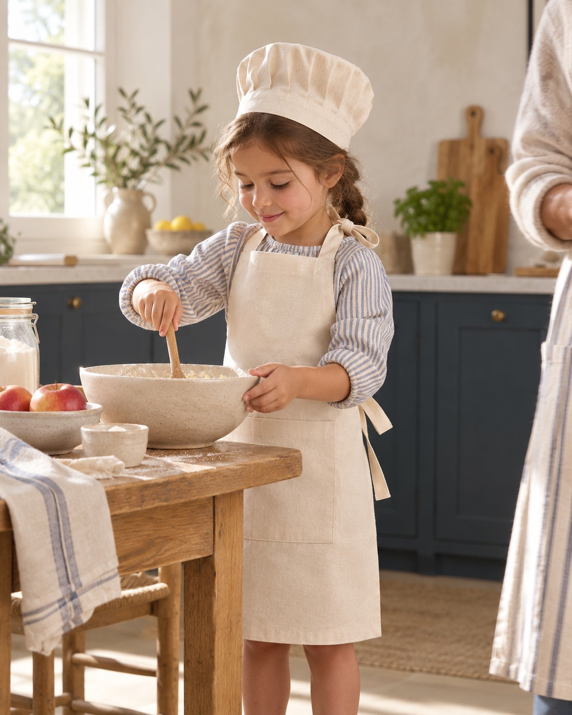 Une enfant prépare le goûter avec son tablier et sa toque.