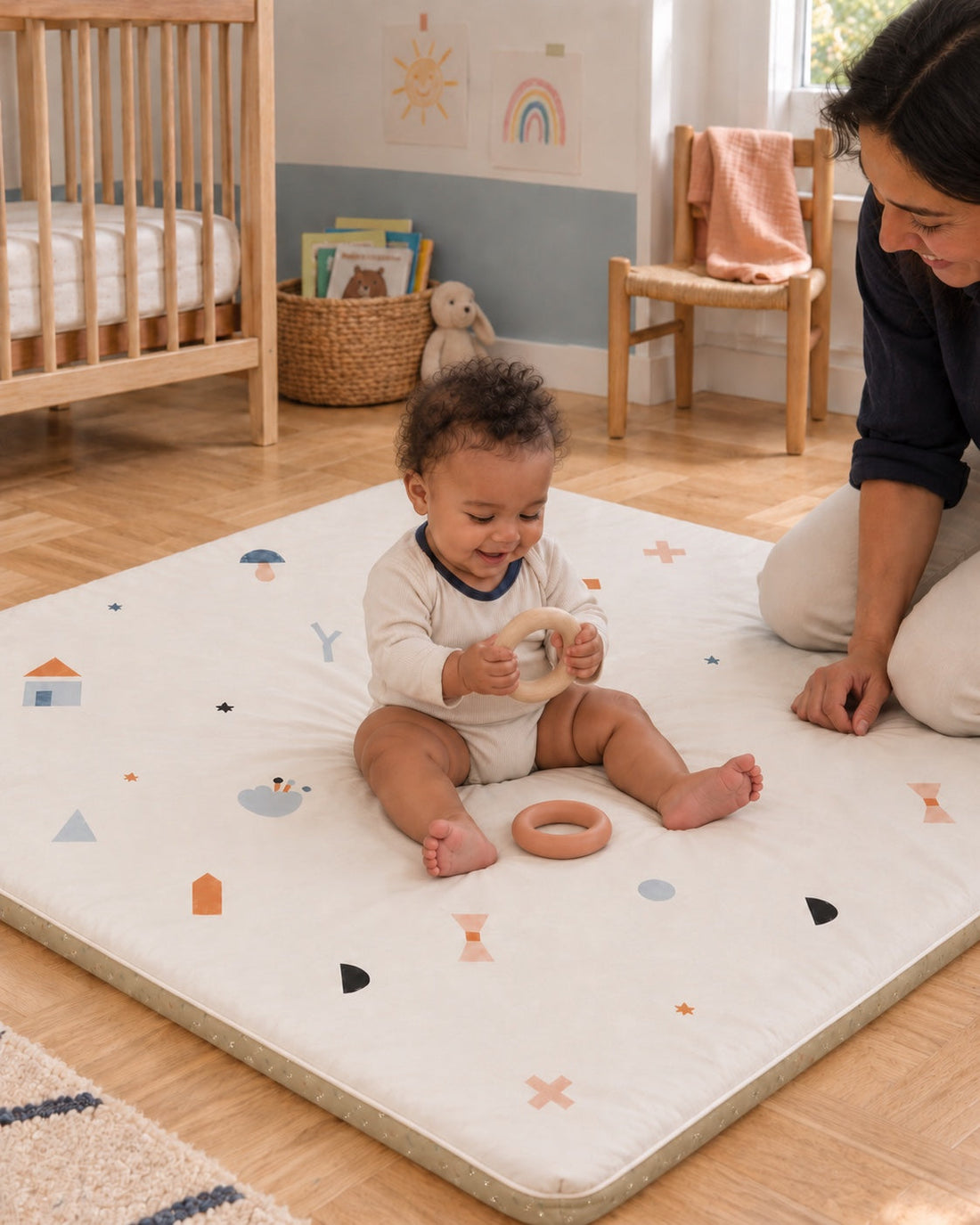 Chaque jour, une découverte. Un bébé assis dans sa chambre explore ses anneaux sur la face écrue du tapis.