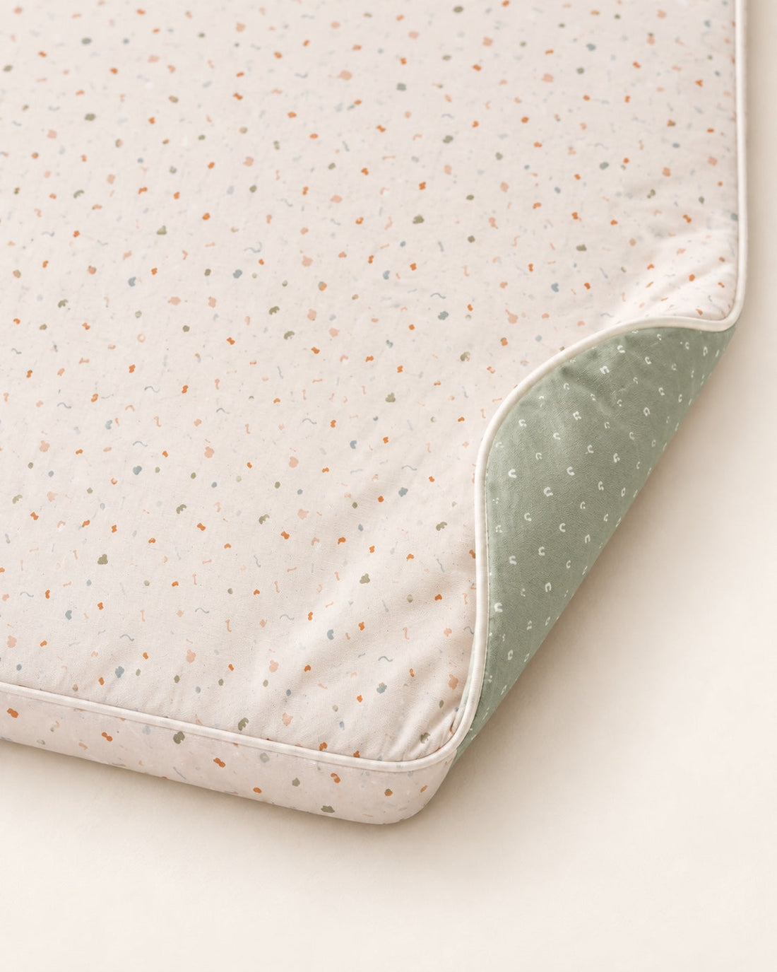 Deux faces, un même tapis. Détail du coin relevé montrant les deux faces, le tissu et la bordure.